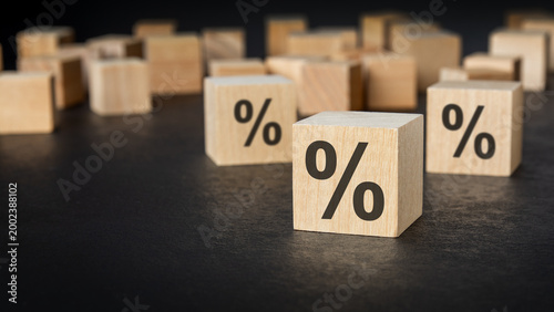 Wooden blocks with percent sign on dark background.