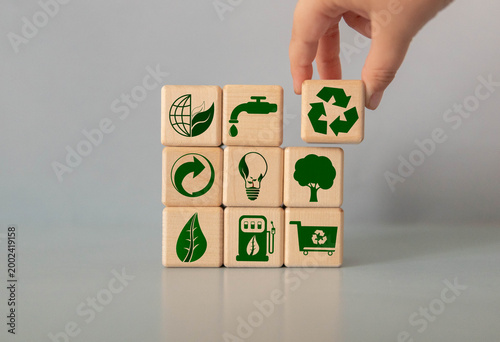 Green and eco building concept. wooden cubes with green building symbols on the natural background.