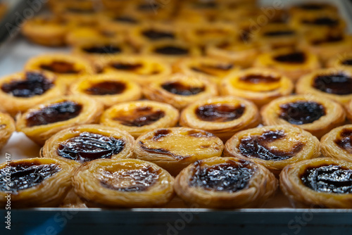 Close-up of freshly baked Pastel De Nata pastries in a bakery display case