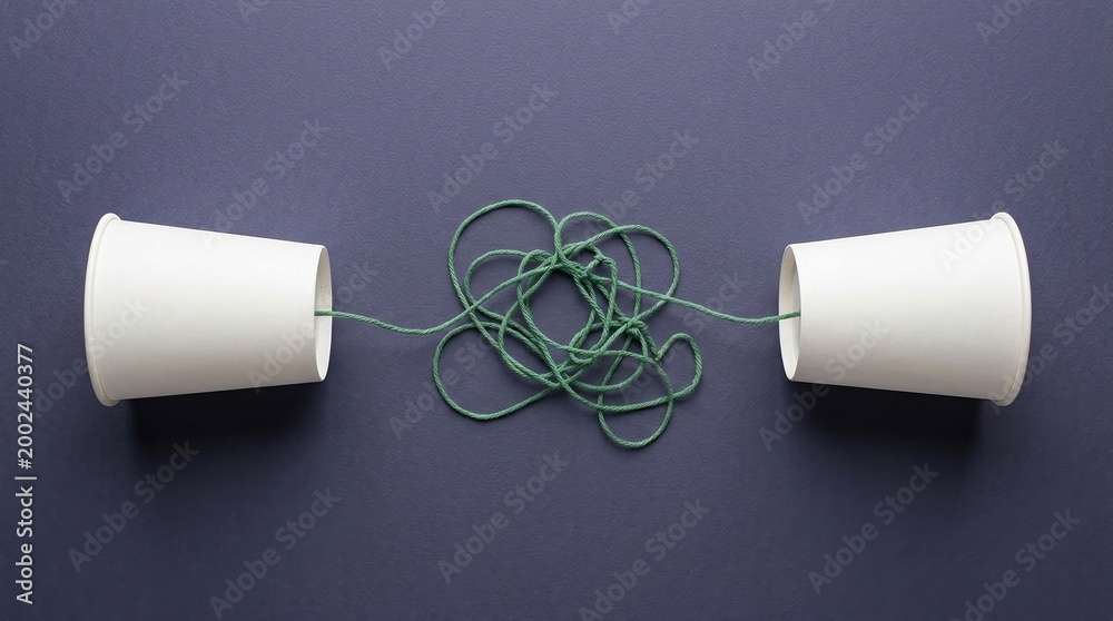 Obraz premium Communication misunderstanding problem confusion tangled connection paper cup phone concept representing business challenges, dialogue breakdown, and complex speech barriers.
