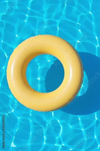 A top-view, moving image of a yellow lifebuoy floating on the water's surface