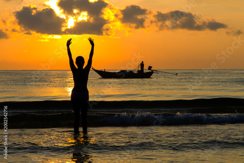 Woman enjoy with sunrise and silhouette