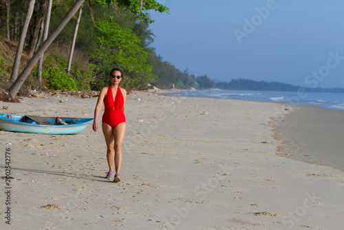 Woman with red swimsuit walk relax on beach