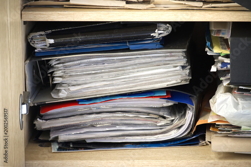 A packed cabinet shows an overwhelming amount of files and documents.
