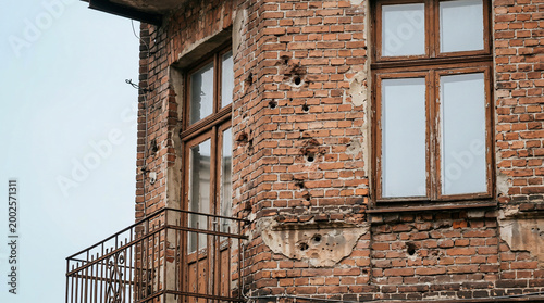 Damaged brick building with bullet holes.