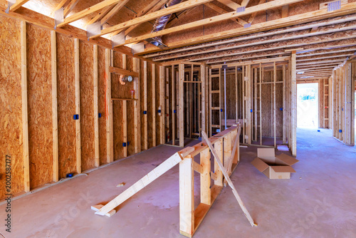 Workers are installing wooden frames in house under construction in residential neighborhood
