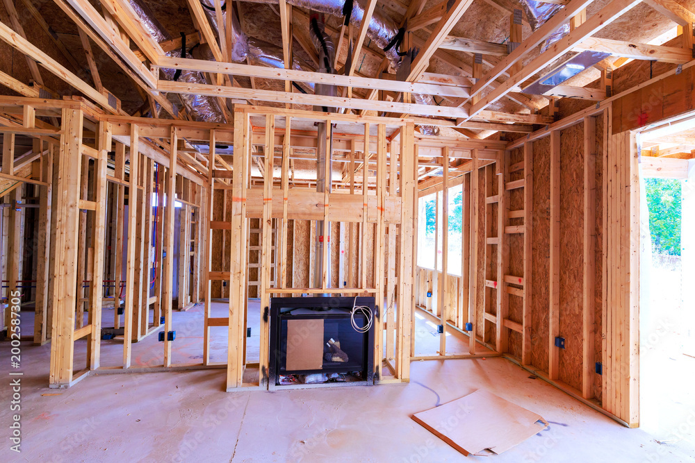 Fototapeta premium Workers are building new house with wooden framing an area set for fireplace floor is clear empty.