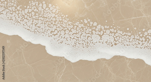 Ocean wave with foam and sand texture aerial view of a serene beach with subtle water ripples perfect for summer vacation and coastal themes