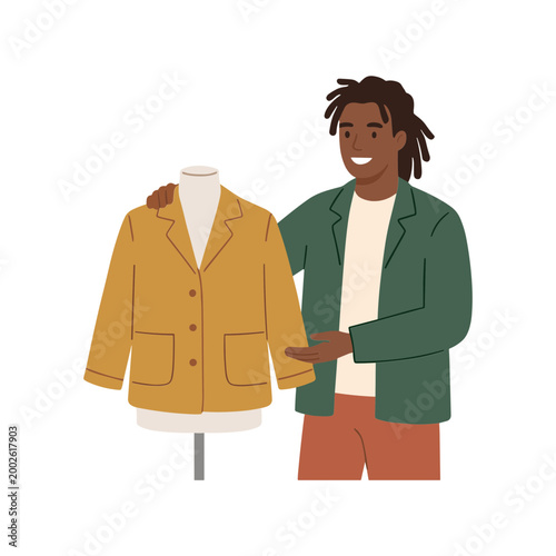 A man displays a yellow jacket on a mannequin in a studio