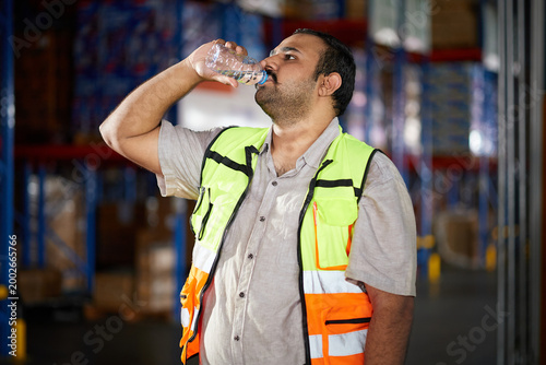 Warehouse worker staying hydrated with a water bottle during a break