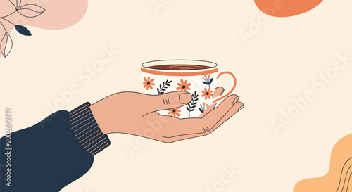 Person holding an ornate floral patterned tea cup with hot steaming beverage against a soft warm background with abstract shapes.