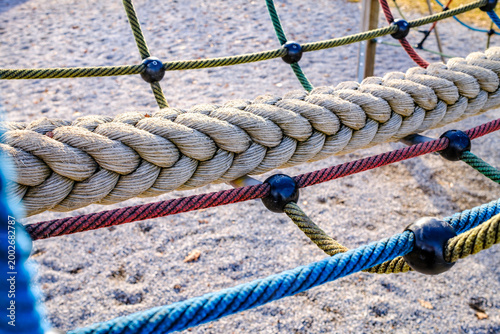 Climbing ropes in a playground structure with bright colors against a clear sky