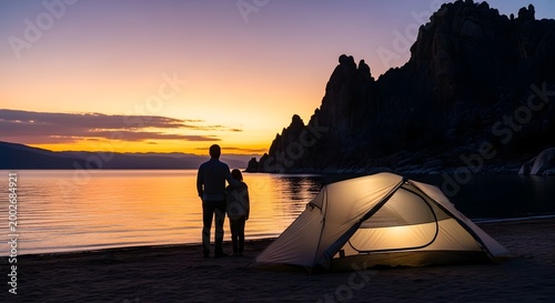 Serene sunset scene with a couple standing by the water near a tent on a peaceful beach with rocky cliffs in the background perfect for outdoor adventure travel camping nature lovers