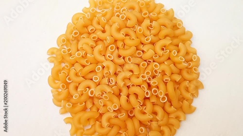 A Pile Of Elbow Macaroni Pasta Rotating on White Background, Uncooked Elbow Macaroni Pasta Ingredient