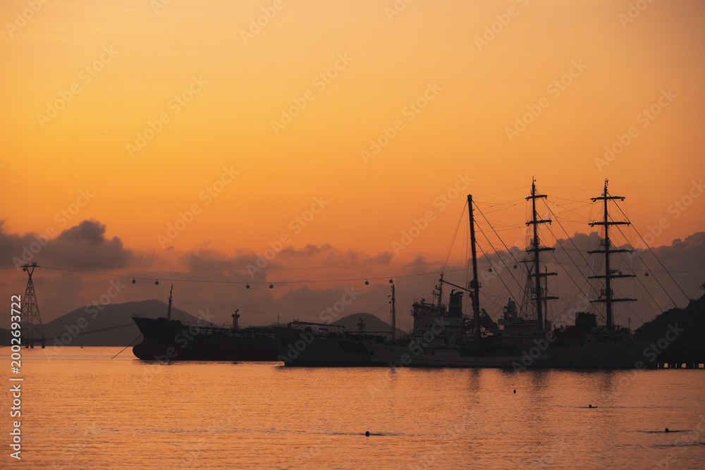 Fototapeta premium Silhouettes of Vietnamese warships military ships in port at sea in the morning at dawn in harbor in Nha Trang in Vietnam