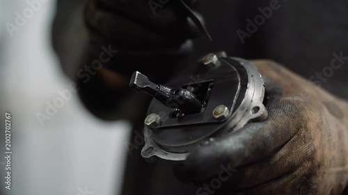 A car mechanic cleans a car part