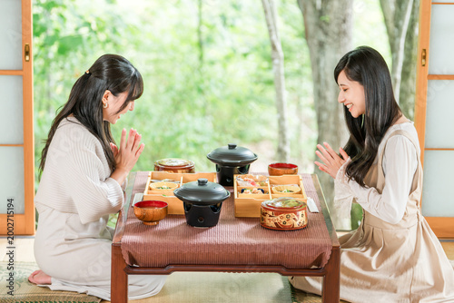 Foto A woman enjoying a kaiseki meal at a traditional Japanese inn (in-room dining, k