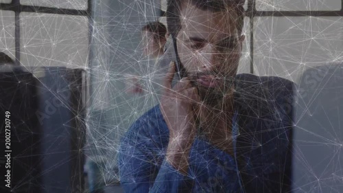 Man raising phone, conducting business call for update, web overlay tracing link to monitor