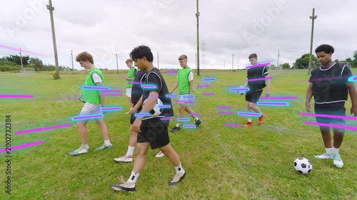 On coach cue boys walking across pitch for drill with soccer balls neon-blue magenta streaks moving