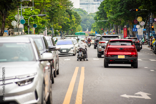 Foto Busy urban traffic scene in Ho Chi Minh City, Vietnam, with cars and motorbikes traveling along a city street