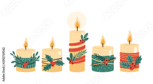 Five traditional advent candles of different heights are decorated with festive holly leaves and red berries for christmas.