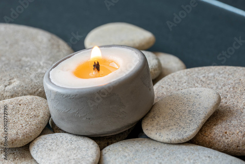 Photography Burning candle on natural stones