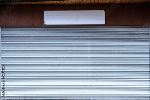 Closed down shop with shutters and removed shop sign