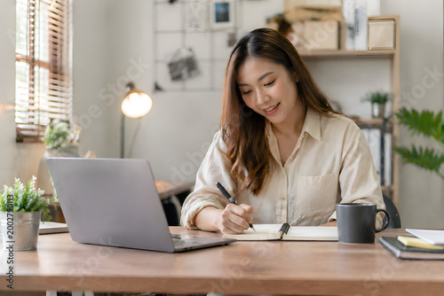 Young Professional Woman Working Remotely on Laptop During Video Conference in Modern Cozy Home Office with Natural Light