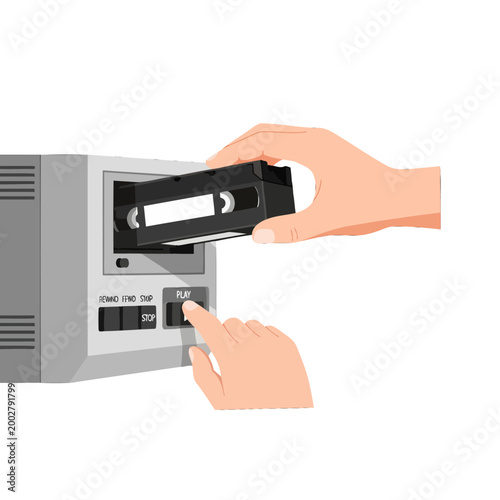 A person inserts a magnetic tape cassette into a vintage video player device