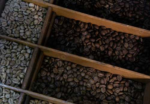 Photos Different stages of coffee beans are displayed in a wooden compartment box