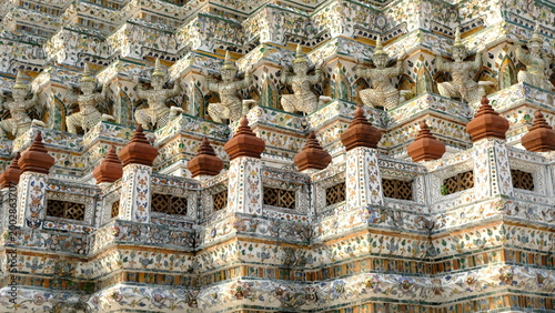 Fotografie Intricate craftsmanship of Temple of Dawn (Wat Arun) featuring mythical giant figures and colorful ceramic tile decorations, historic landmark in Bangkok