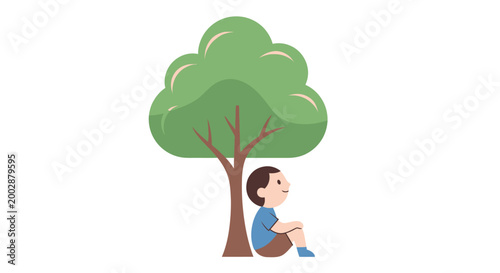 Boy sitting under a tree.