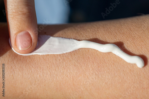 Fotografi sunscreen cream skin protection hand applying white lotion on arm close up for