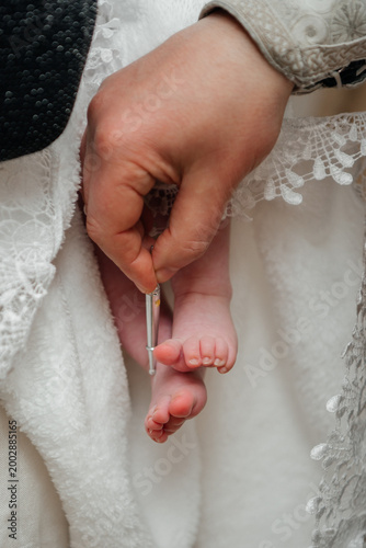 Tableau sur toile A significant moment of the Orthodox baptism ritual where a priest uses a special brush to anoint a baby's foot with holy chrism (myrrh)