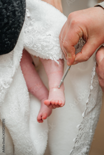 Photos A significant moment of the Orthodox baptism ritual where a priest uses a special brush to anoint a baby's foot with holy chrism (myrrh)
