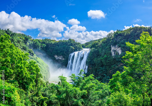 Panoramic view of Huangguoshu Waterfall surrounded by lush green forest in Anshun, Guizhou, China