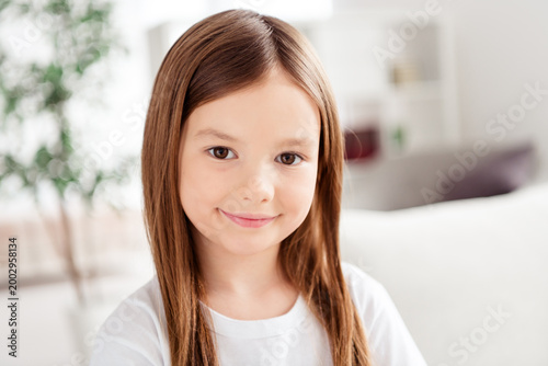 Free Download Friendly young girl portrait smiling at home, natural light child portrait conveying happiness and family warmth - GFXLoad