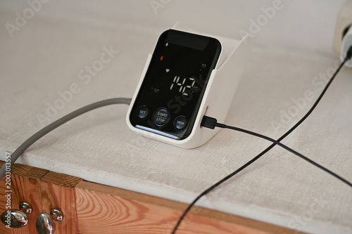 Quadro su tela Close up of woman measuring her blood pressure with digital blood pressure monit