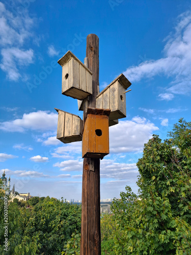 Five wooden birdhouses on one pole