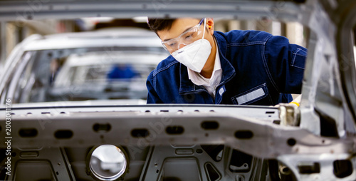 Tableau sur toile Asian workers are working on a car assembly line.