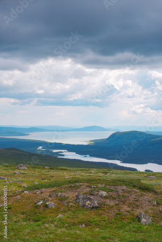Panoramic view of Kungsleden hiking trail in Laponia World Heritage Site Sweden with vast arctic tundra landscape under summer sky