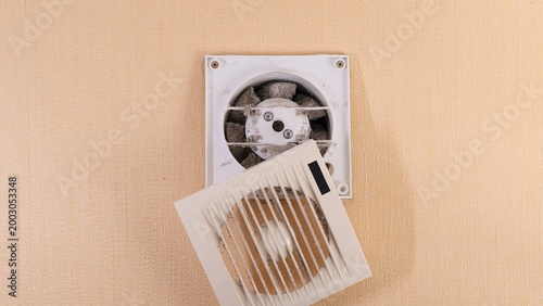 Foto Dirty exhaust fan with its cover removed, revealing heavy dust accumulation insi