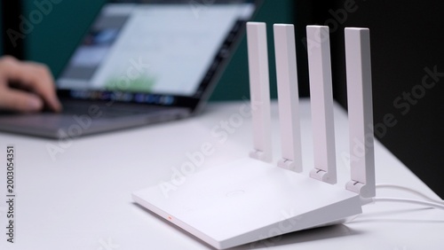 Tableau sur toile White wi fi router providing high speed internet access on a desk, with a person