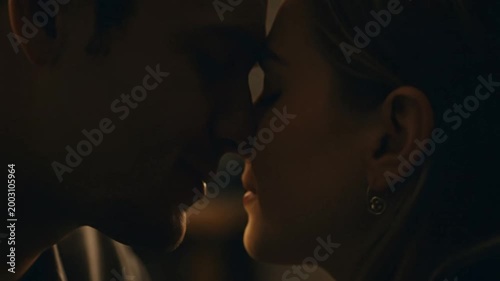 Intimate young couple facing each other in cinematic warm lighting