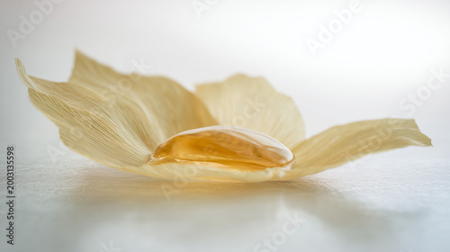 Abstract 3D render of a golden oil globule on dry leaf petals, luxurious organic cosmetics background
