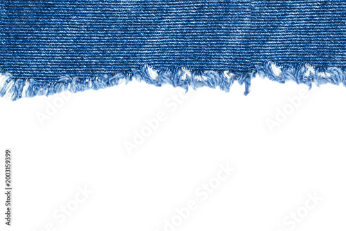 Fotografie Denim fabric with frayed edge shows a close-up of its texture and color in well-