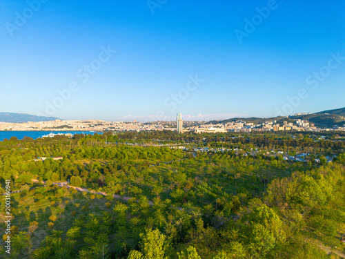 Obraz na plátne Expansive green parkland overlooks a bustling city skyline and calm blue bay