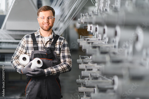 Factory worker holding polypropylene yarn spools in textile production