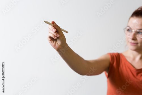 Focused woman holding a pen...