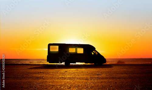 Wohnmobil im Gegenlicht am Strand